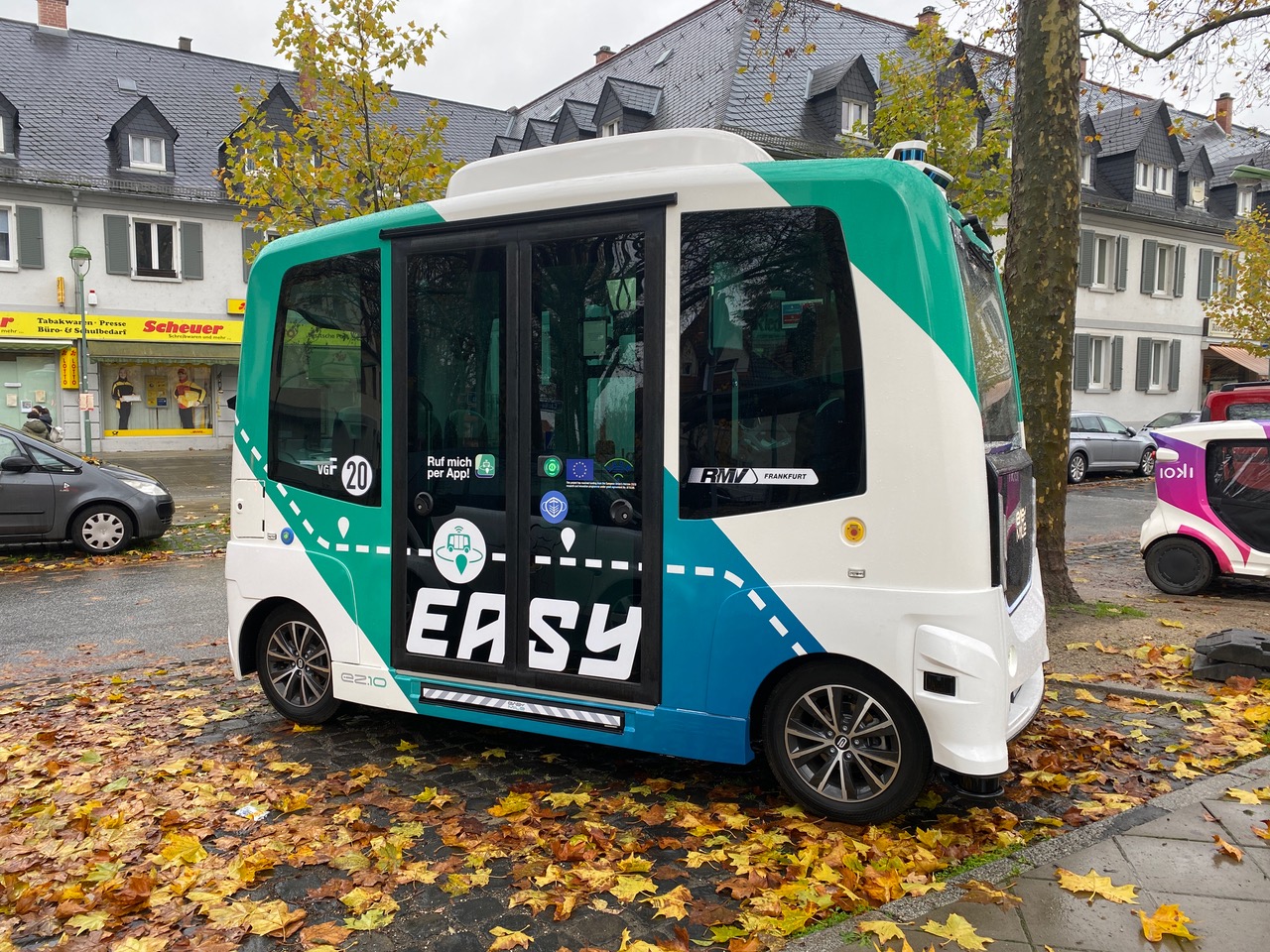 AV-Bus auf einem Parkplatz mit Herbstlaub