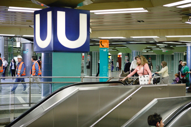 Eine Frau fährt in einer B-Ebene auf einer Rolltreppe zum Bahnsteig der U-Bahnhaltestelle hinunter. 