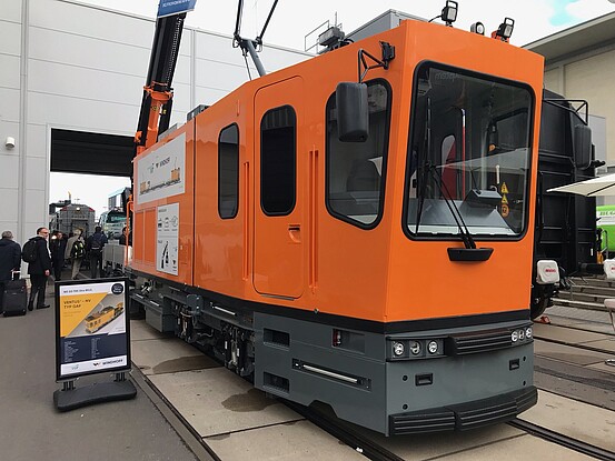 Das Gleisarbeitsfahrzeug GAF: ein Schienenfahrzeug in Orange mit einem Anhänger und vielen technischen Elementen.